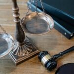 From above of judicial symbols consisting of Scales of Justice and small judge hammer with curly handle